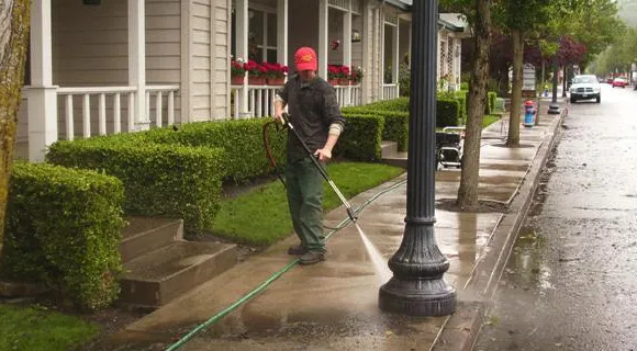 Portland exterior cleaning crew soft-washing a two-story cedar-sided home with a low-pressure wand